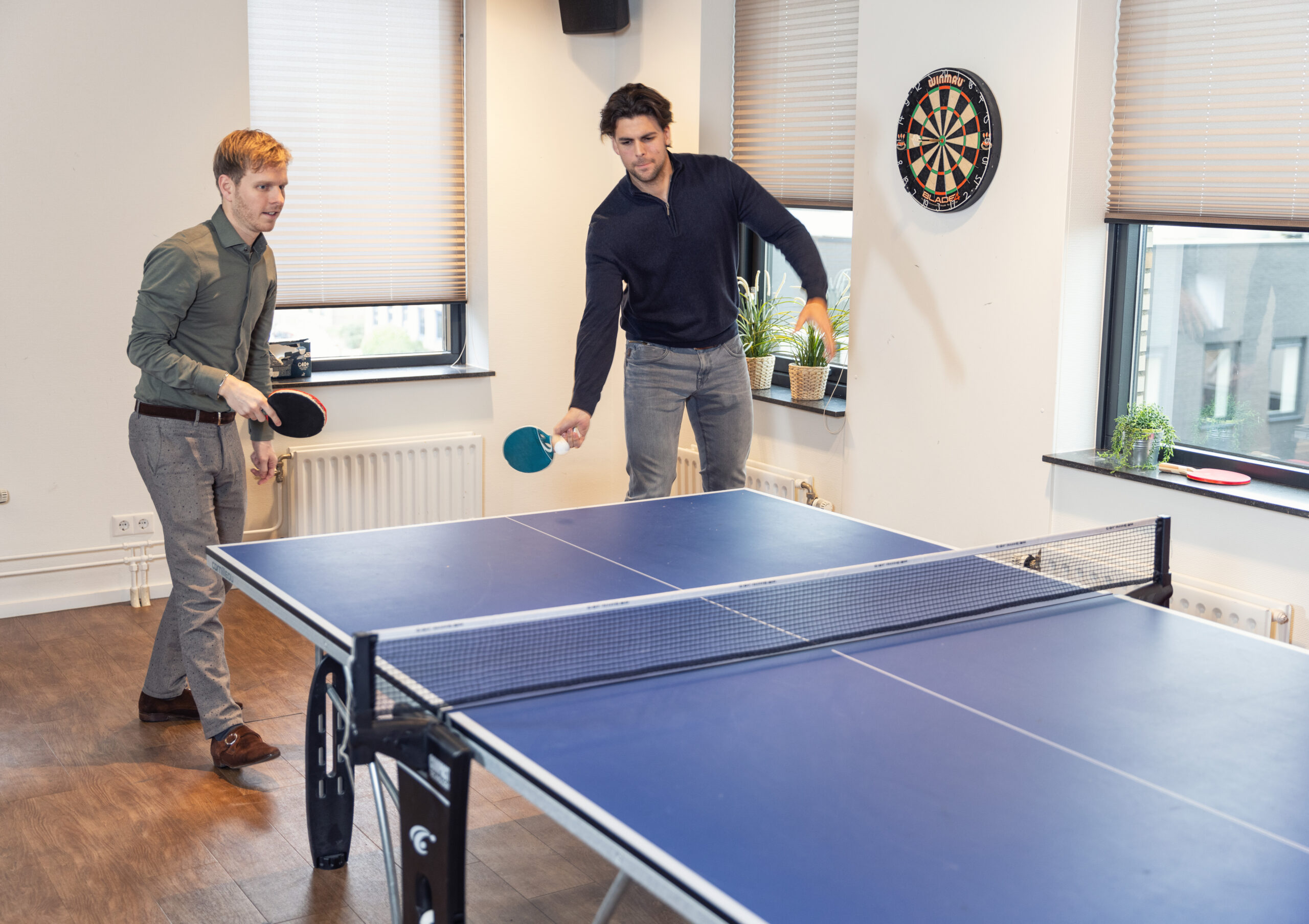 afbeelding van collega's die tafeltennissen